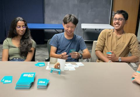 3 teens playing What do you meme game
