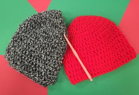 Two crochet hats and a crochet hook