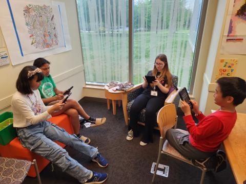 A group of teens playing games on a tablet