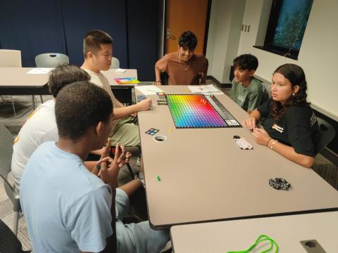 group of teens playing Hues and Cues board game