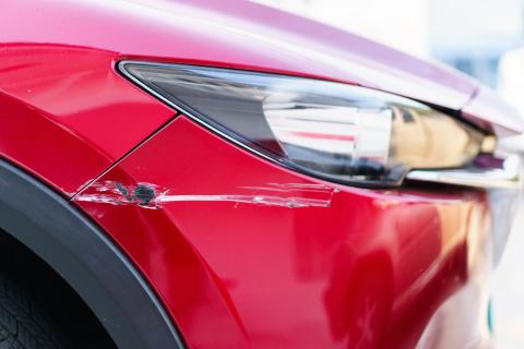 A red car with passenger side damage.
