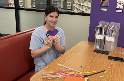 teen girl holding a purple paper heart