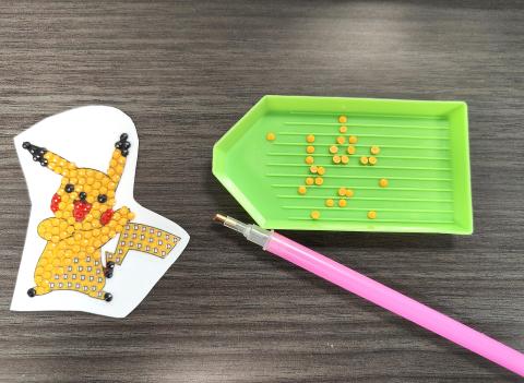 Pikachu diamond painting sticker with green tray, yellow beads, and pink diamond tool