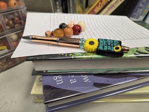 Beaded pen on a stack of books