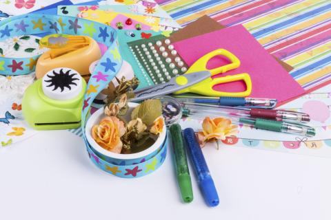 Pile of paper, scissors, pens and punches