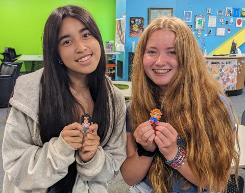 Two girls holding their Perler Bead creations.