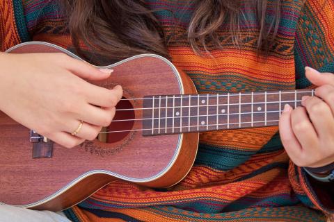 Brunette woman playing a ukulele