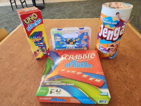 Table with UNO Stack-O, Scrabble Upword, Jenga, and Stacking Game.