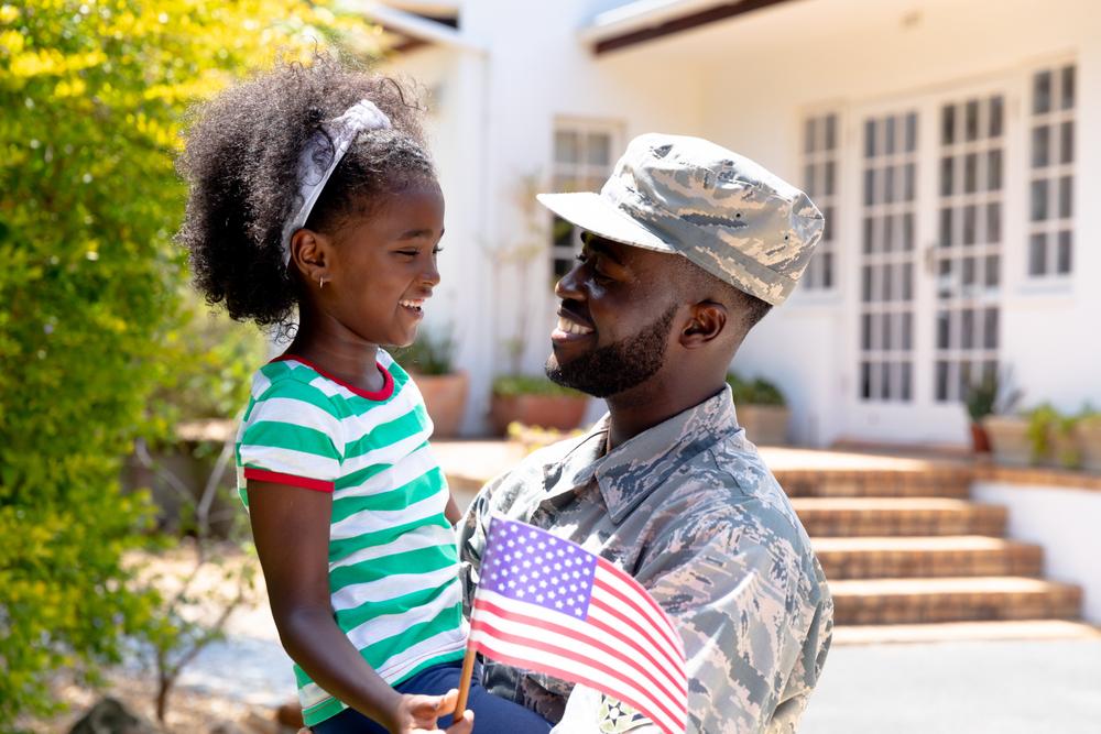 male soldier holding his daughter