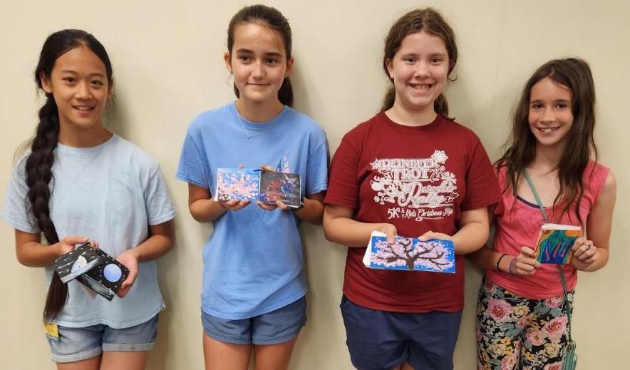 A group of teens with their painted canvas journals.