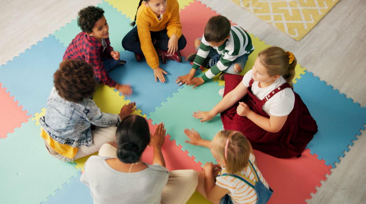 students and teacher sitting in a circle