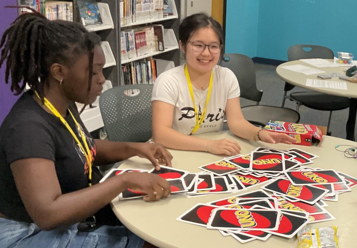 2 female teens and large UNO cards