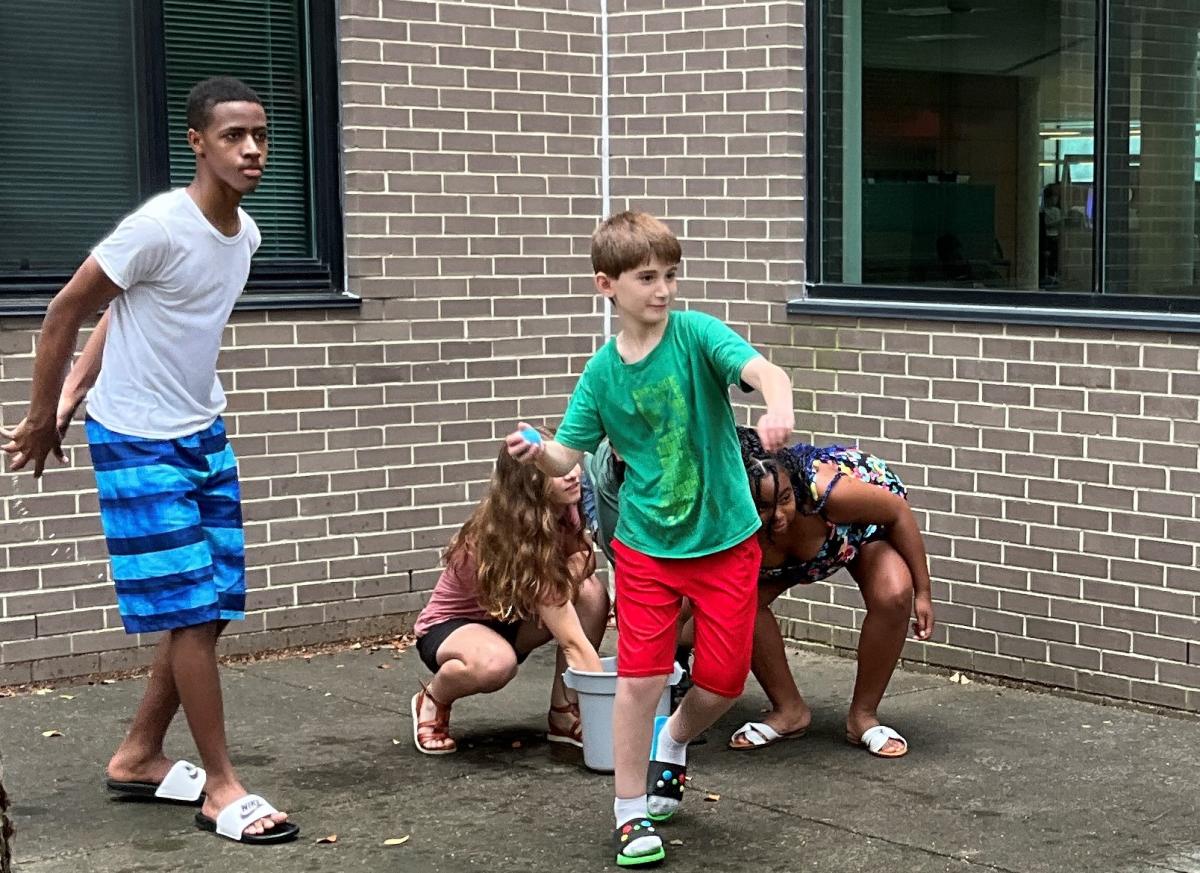 2 boys and 2 girls playing water balloons