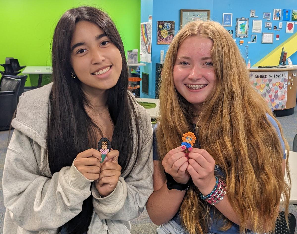 Two girls holding their Perler Bead creations.