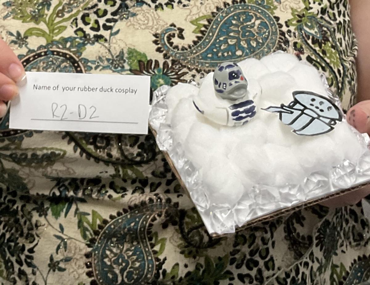 rubber duck painted as R2-D2, next to Millennium Falcon on bed of cotton