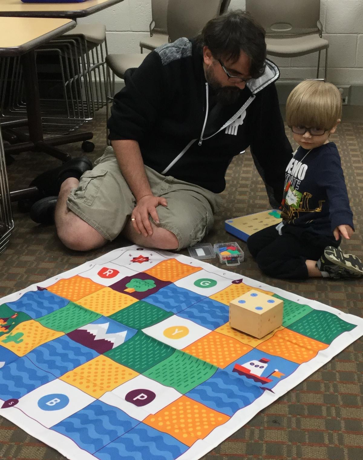 parent helping children move robot 