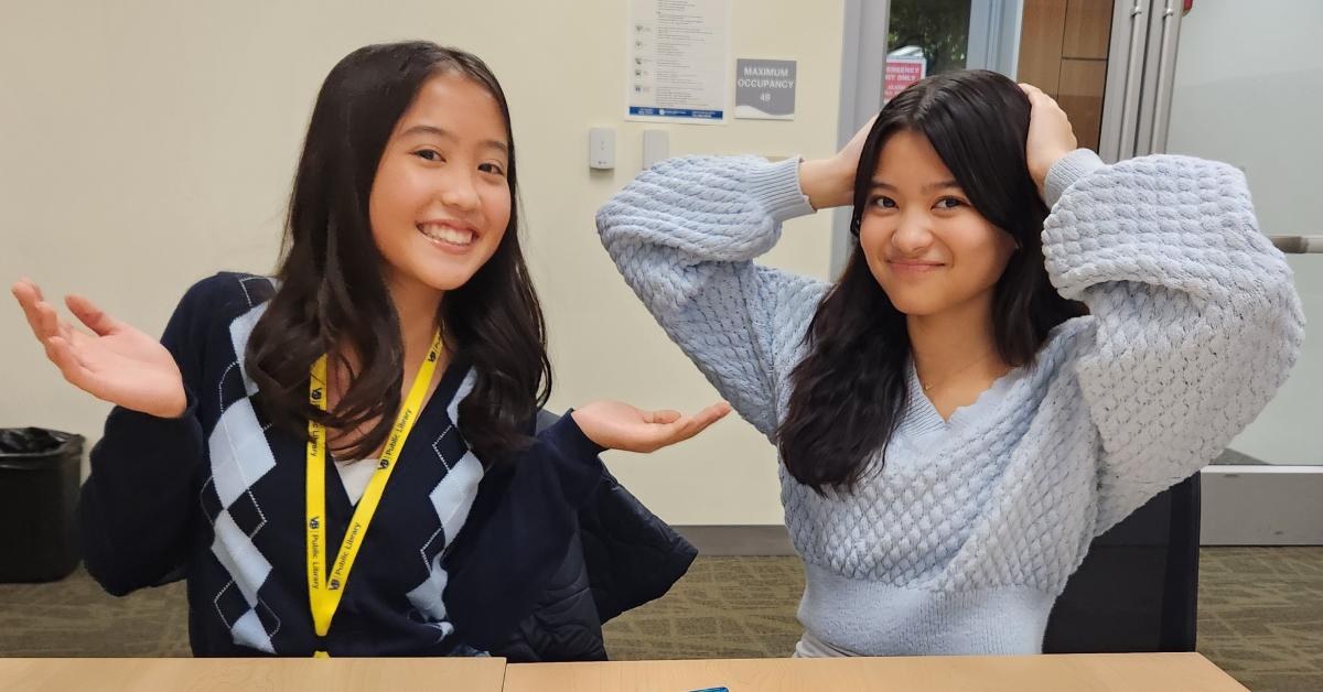 Two girls throwing up their hands in playful confusion.