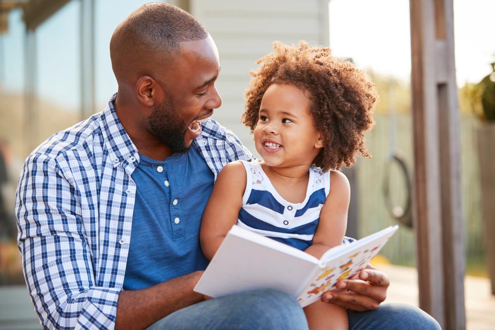 father and daughter reading a book