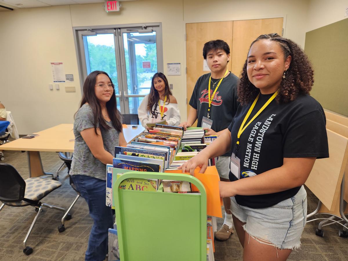 Group of teens around book cart after stamping each book