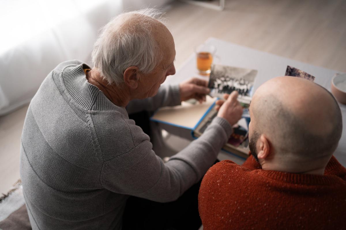 two men looking at family photos