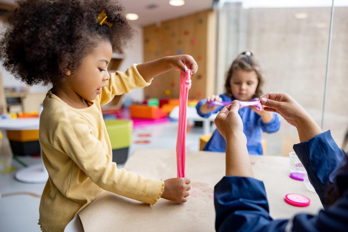 Children playing with a squishy, play-dough like substance at a table