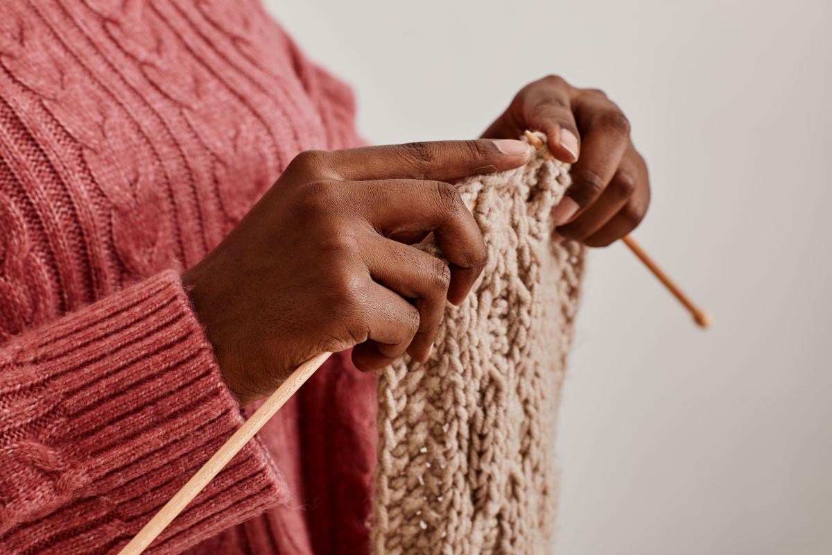 A person's hands knitting.